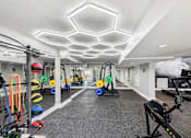 Thumbnail 16 of 25 - Pet-Friendly Apartments in Sandy Springs– Celebration at Sandy Springs – A well-lit gym with various exercise equipment.