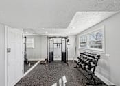 Thumbnail 18 of 25 - Sandy Springs, GA Apartments – Celebration at Sandy Springs – gym with a variety of equipment including a squat rack, bench, and dumbbells.