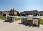 Thumbnail 18 of 31 - Apartments for Rent in Oak Ridge, TN 37830 – Centennial Village – a pool with two grills and chairs in front of a building