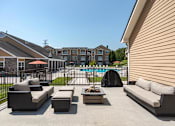 Thumbnail 17 of 31 - Apartments for Rent in Oak Ridge, TN 37830 – Centennial Village – a poolside patio with couches and a table