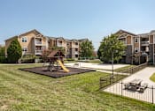 Thumbnail 20 of 31 - Apartments for Rent in Oak Ridge, TN 37830 – Centennial Village – a playground in a yard in front of an apartment building