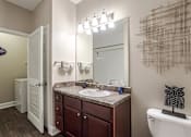 Thumbnail 11 of 31 - Pet-Friendly Apartments in Oak Ridge, TN – Centennial Village – a bathroom with a sink toilet and a mirror