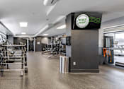 Thumbnail 18 of 25 - A gym with a variety of equipment including weights and cardio machines.