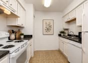 Thumbnail 8 of 23 - A kitchen with white appliances and cabinets.