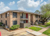 Thumbnail 27 of 28 - a brick apartment building with a red door and a sidewalk