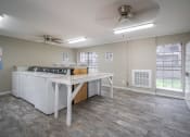 Thumbnail 26 of 28 - an empty kitchen with an island and a stove and a window