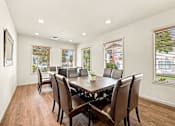 Thumbnail 40 of 47 - A large brown dining table with chairs is in a room with windows.