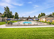 Thumbnail 30 of 47 - A sunny day at a community pool with a few people relaxing.
