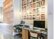 Thumbnail 10 of 17 - A room with a desk and a wall of pictures.