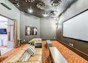 Thumbnail 14 of 17 - A modern living room with a large couch and a flat screen TV.