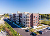Thumbnail 22 of 22 - Aerial view of the apartment community exterior with balconies and waterfront scenery at Creekline at Fairfield, Fairfield CT.