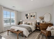 Thumbnail 5 of 22 - Staged apartment bedroom with large window and modern furnishings at Creekline at Fairfield in Fairfield, Connecticut.
