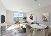 Thumbnail 10 of 22 - Open-concept living and dining area at Creekline at Fairfield Apartments in Fairfield, CT with large windows, modern furnishings, natural light, and wood-style flooring.