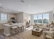 Thumbnail 2 of 22 - Bright open-concept kitchen and living area at Creekline at Fairfield apartments in Fairfield, CT, featuring light wood cabinetry