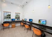 Thumbnail 23 of 28 - A room with a long desk and chairs with computers on it.