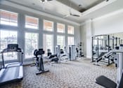 Thumbnail 3 of 20 - A spacious gym with a variety of equipment and large windows.