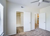 Thumbnail 10 of 20 - A room with a ceiling fan and three doors.