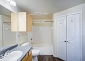 Thumbnail 13 of 20 - A white bathroom with a toilet, sink, and bathtub.