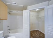 Thumbnail 14 of 20 - A white bathroom with a tub, toilet, and sink.