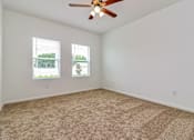 Thumbnail 67 of 75 - A room with a ceiling fan and carpeted floor.