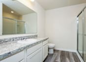 Thumbnail 12 of 38 - A bathroom with a marble countertop and a toilet.