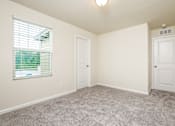 Thumbnail 36 of 38 - A room with a carpeted floor and two doors.