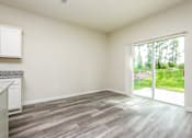 Thumbnail 14 of 38 - A room with a sliding glass door leading to a garden.