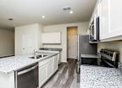 Thumbnail 25 of 38 - A kitchen with granite countertops and stainless steel appliances.