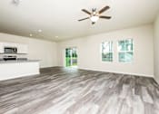 Thumbnail 13 of 38 - A spacious room with a ceiling fan and wooden flooring.