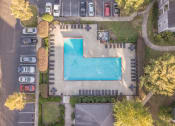 Thumbnail 27 of 29 - Twin Oaks Apartments in Hattiesburg Mississippi photo of arial view of a swimming pool in a yard with cars parked in the parking lot