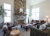 Thumbnail 5 of 16 - A living room with a stone fireplace and a variety of seating options.