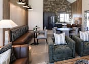 Thumbnail 6 of 16 - A living room with a stone wall and a large sectional sofa.