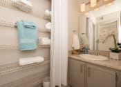 Thumbnail 15 of 31 - Apartments in Lawrenceville Georgia for Rent – Park on Sweetwater - a bathroom with a sink and a mirror and a shower