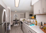 Thumbnail 8 of 31 - Pet-Friendly Apartments in Lawrenceville– Park on Sweetwater – a renovated kitchen with stainless steel appliances and white cabinets