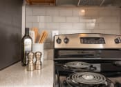 Thumbnail 6 of 31 - Apartments in Lawrenceville Georgia for Rent – Park on Sweetwater - a kitchen with a stove and a bottle of wine on the counter