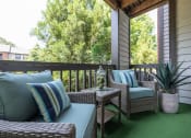 Thumbnail 17 of 31 - Lawrenceville, GA Apartments – Park on Sweetwater – a covered porch with wicker furniture and a window