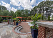 Thumbnail 19 of 31 - Lawrenceville, GA Apartments – Park on Sweetwater – a patio with brick pillars and a seating area with potted plants