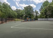 Thumbnail 20 of 31 - Apartments For Rent In Lawrenceville, GA - Park On Sweetwater Apartments - Outdoor Fenced-In Tennis Court Next To Playground