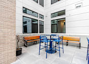 Thumbnail 50 of 54 - A patio with a table and chairs and a potted plant.
