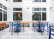 Thumbnail 48 of 54 - A patio with blue chairs and orange benches.