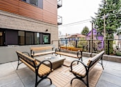 Thumbnail 47 of 54 - A wooden bench sits on a patio in front of a building.