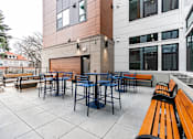 Thumbnail 49 of 54 - A patio with a table and chairs is surrounded by benches.