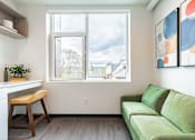Thumbnail 16 of 54 - A living room with a green couch and a painting on the wall.