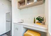 Thumbnail 14 of 54 - A kitchen with a white counter and a yellow stool.