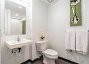 Thumbnail 18 of 54 - A bathroom with a toilet, sink, and towels.