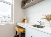 Thumbnail 30 of 54 - A kitchen with a white counter and a window.