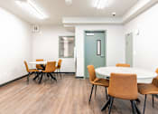 Thumbnail 42 of 54 - A conference room with a white table and brown chairs.