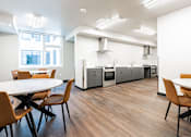 Thumbnail 41 of 54 - A modern kitchen with a dining table and chairs.