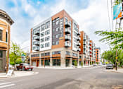 Thumbnail 53 of 54 - A street view of a residential area with apartment buildings and cars.