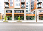Thumbnail 54 of 54 - A modern multi-story building with balconies and glass doors.
